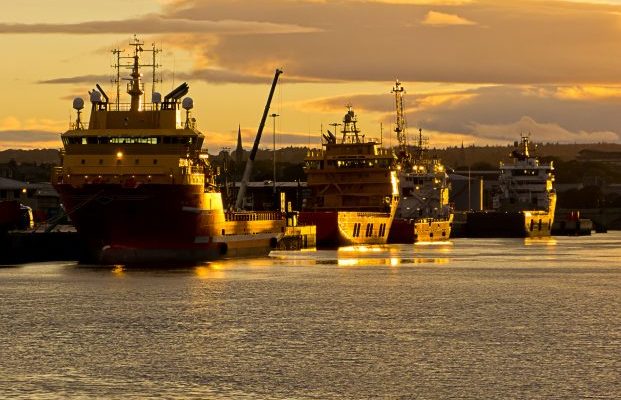 Four ships moored in Aberdeen harbour as the sun sets.